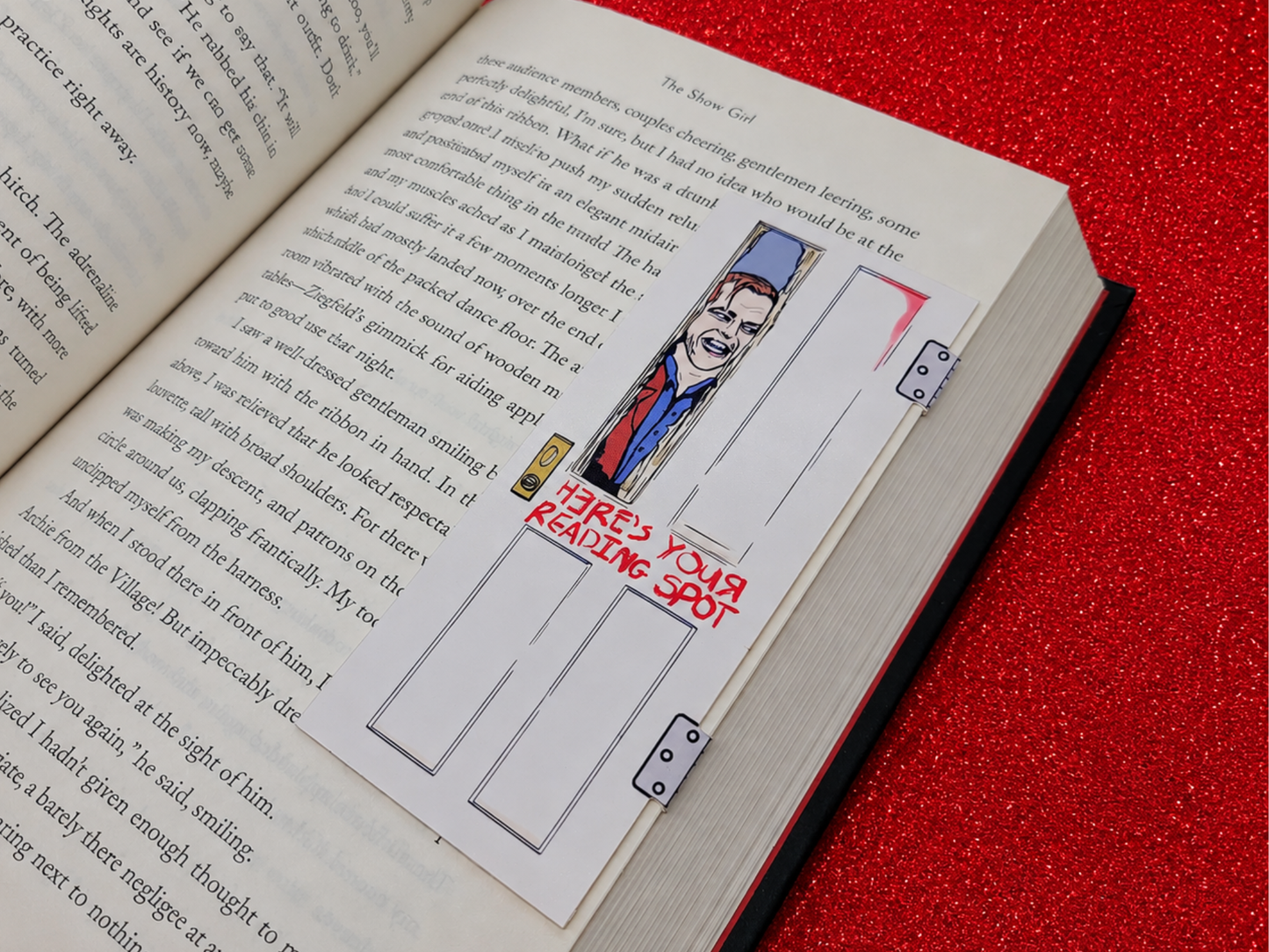 A magnetic bookmark inspired by Jack Torrance featuring him breaking through the wooden bathroom door with an axe. The words on the door read, "Here's your reading spot!"