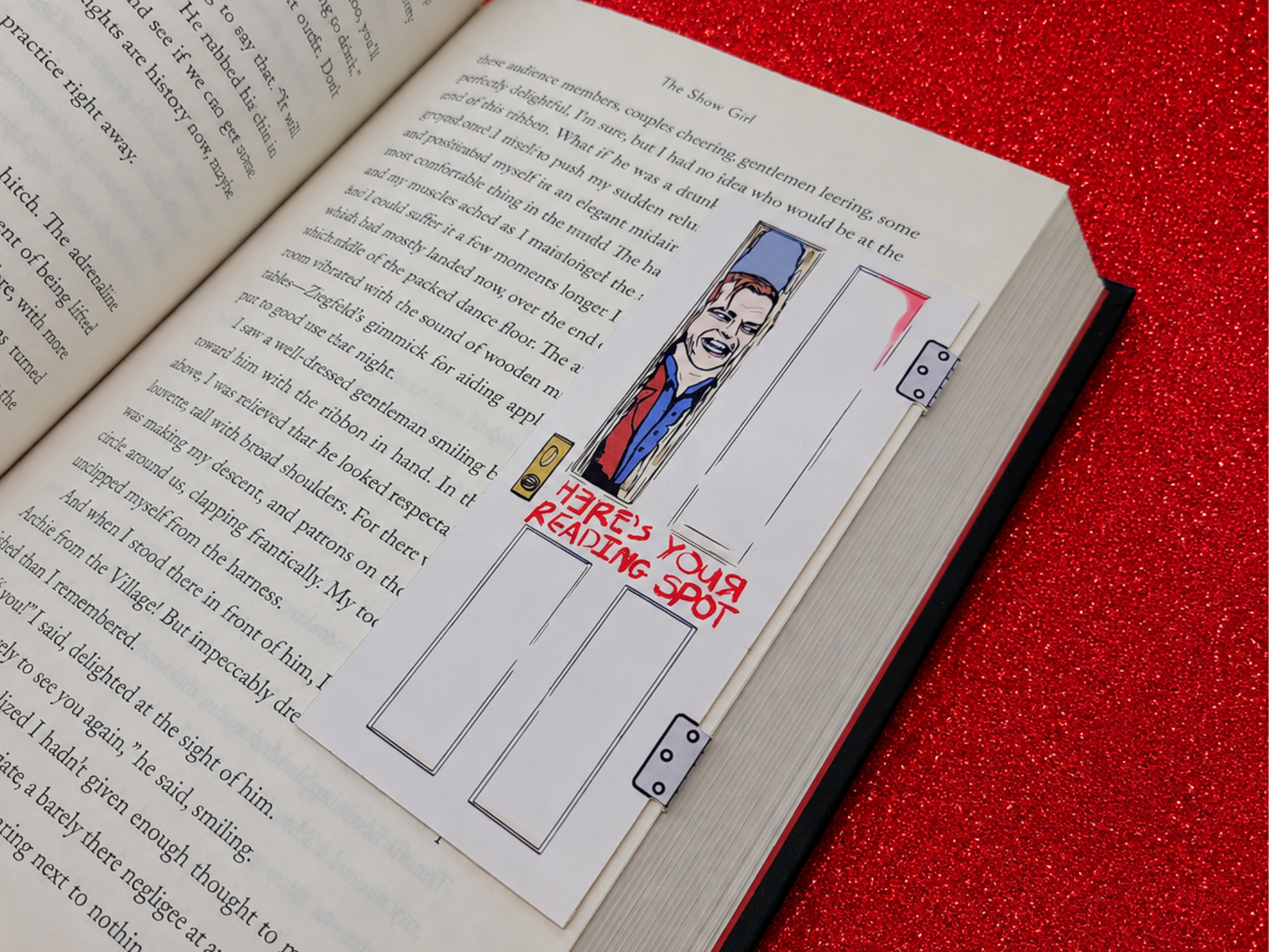 A magnetic bookmark inspired by Jack Torrance featuring him breaking through the wooden bathroom door with an axe. The words on the door read, "Here's your reading spot!"