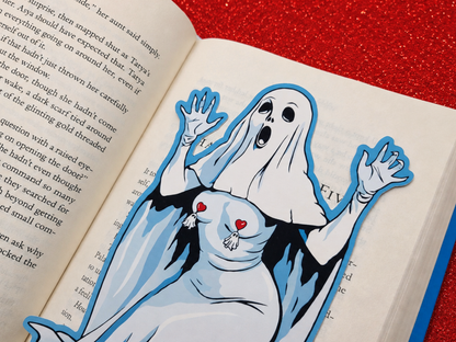 A high-quality, large 7-inch die-cut ghost bookmark resting on a hardcover book. The bookmark features a dramatic, original illustration ghost with a shocked face and wearing tiny, dangling ghost tassel pasties.