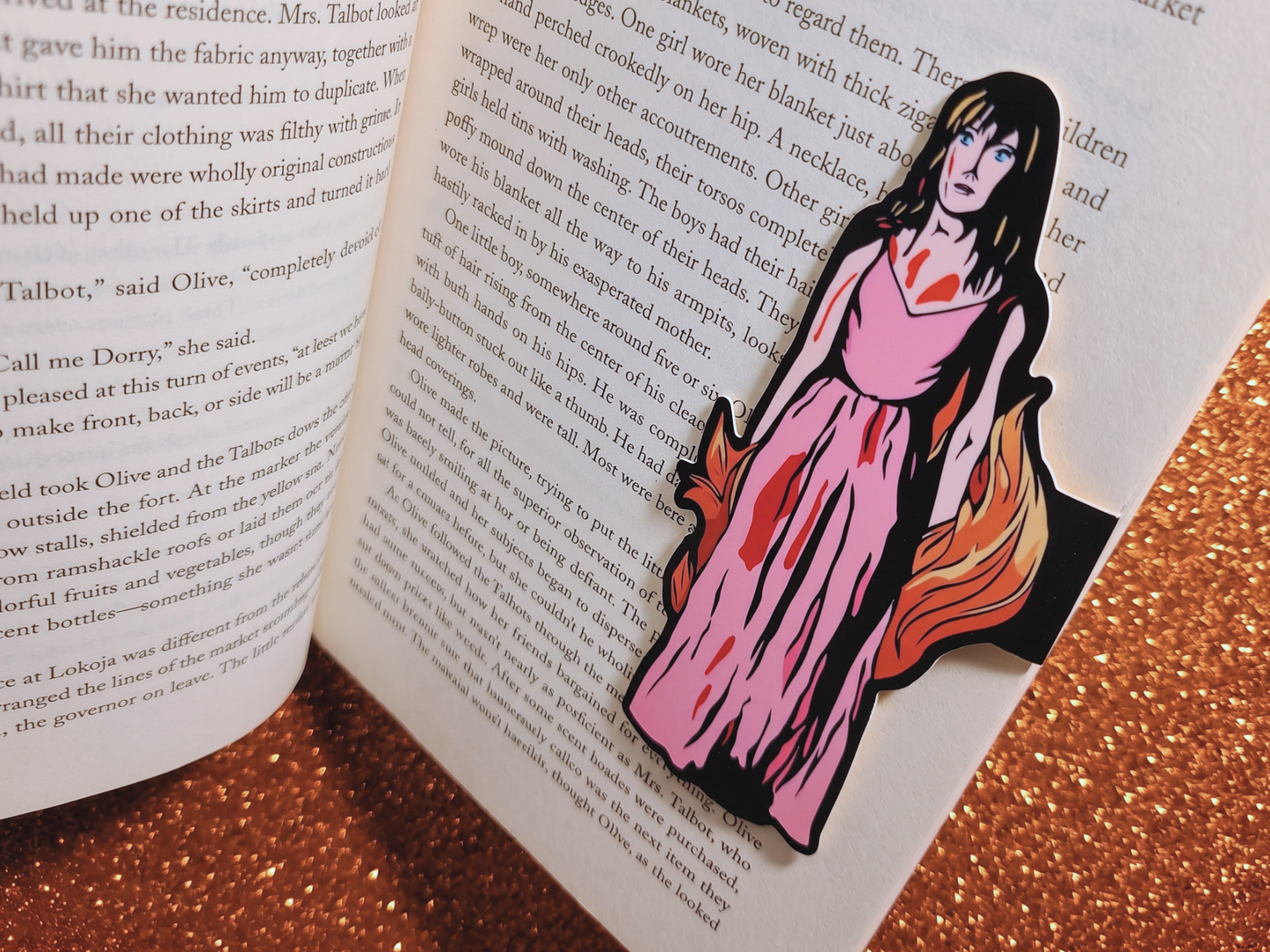 Close-up shot of a Carrie Magnetic Bookmark securely clipped over a few pages of an open book, showcasing the premium, glare-free satin finish of the cardstock.