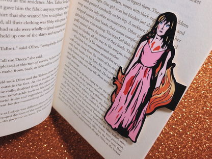Close-up shot of a Carrie Magnetic Bookmark securely clipped over a few pages of an open book, showcasing the premium, glare-free satin finish of the cardstock.