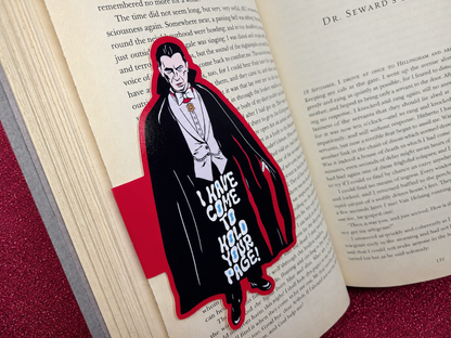 A magnetic bookmark featuring an original illustration of Dracula in a black cape. The text on the bookmark reads, "I have come to hold your page!"