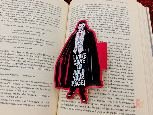 The Dracula magnetic bookmark resting on an open book. The bookmark stands at 5 inches tall.