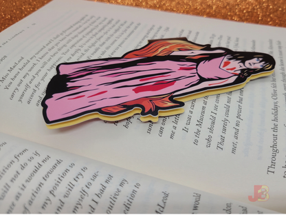 Carrie magnetic bookmark laying on top of an open book.