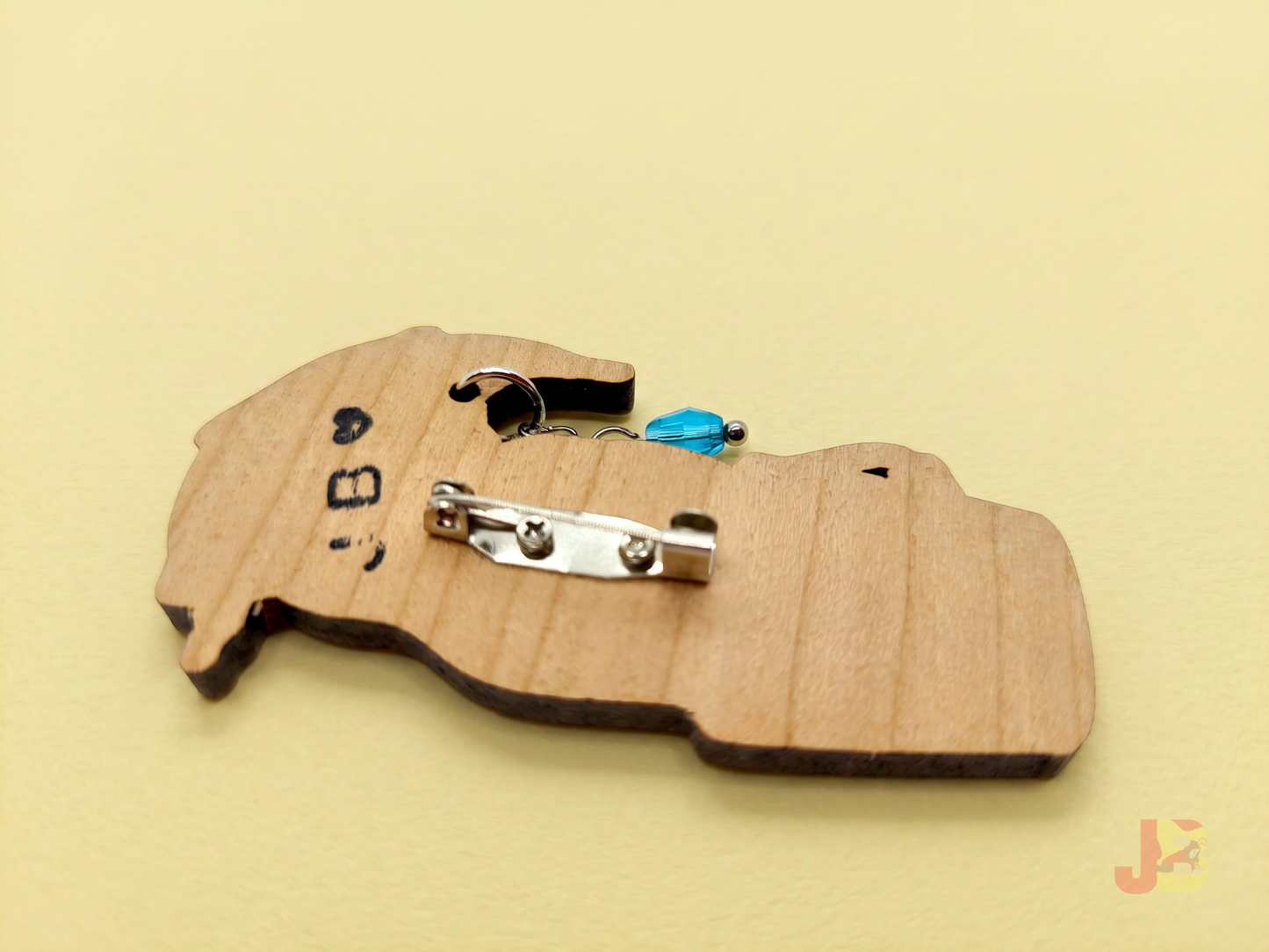 The back of the wooden snowman brooch with a pin-backing screwed on for durability.