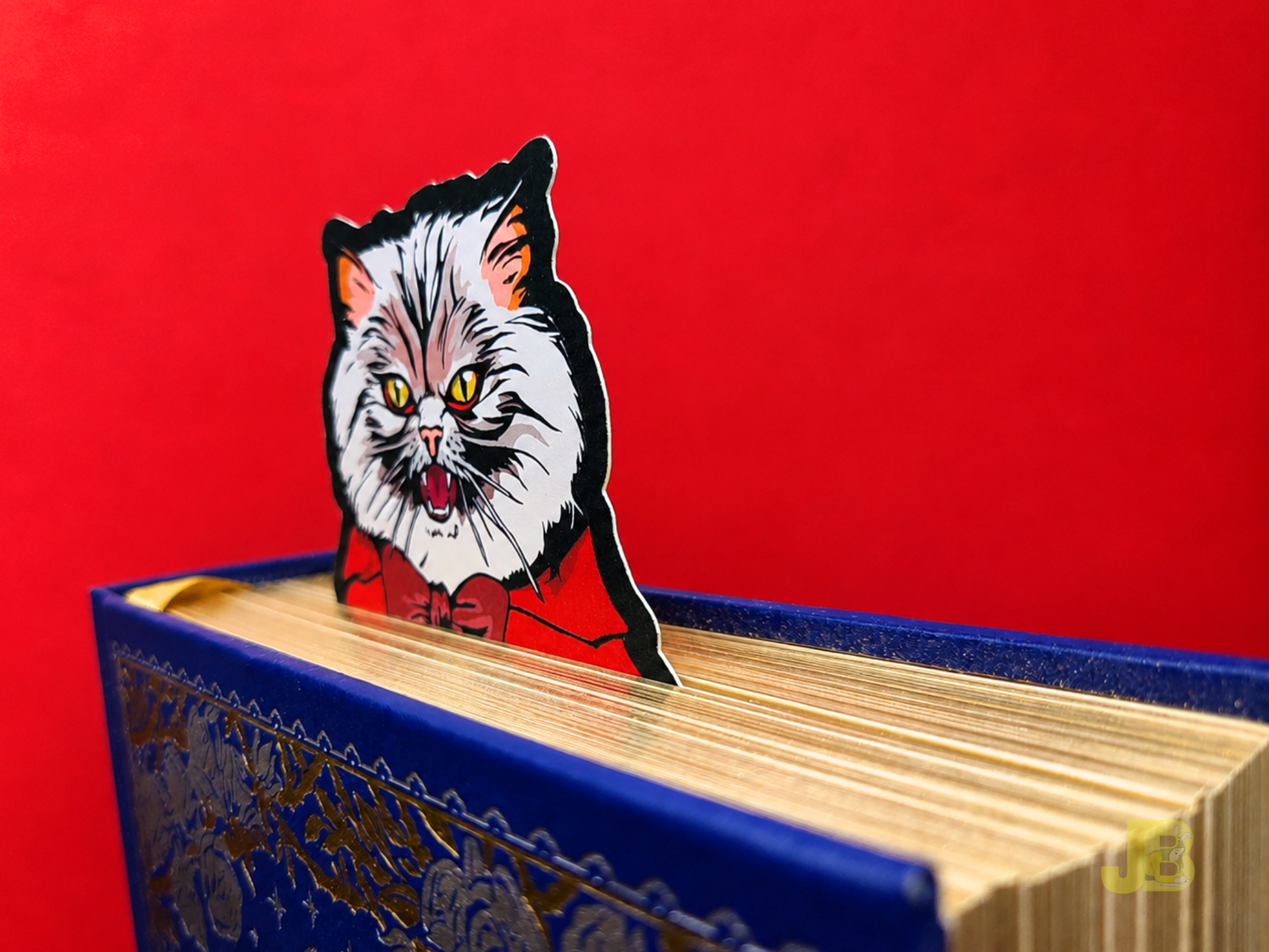 A Count Pallas vampire cat bookmark peeking out from the top pages a thick hardcover book. It features a Pallas Cat with fangs and a grumpy expression. Perfect for dark academia and romantasy readers.