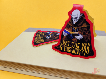 Two magnetic bookmarks resting on top of a hardcover novel featuring original art of the classic horror movie vampire, Nosferatu. The creepy Count Orlok illustration is printed on high-quality, durable coverstock.